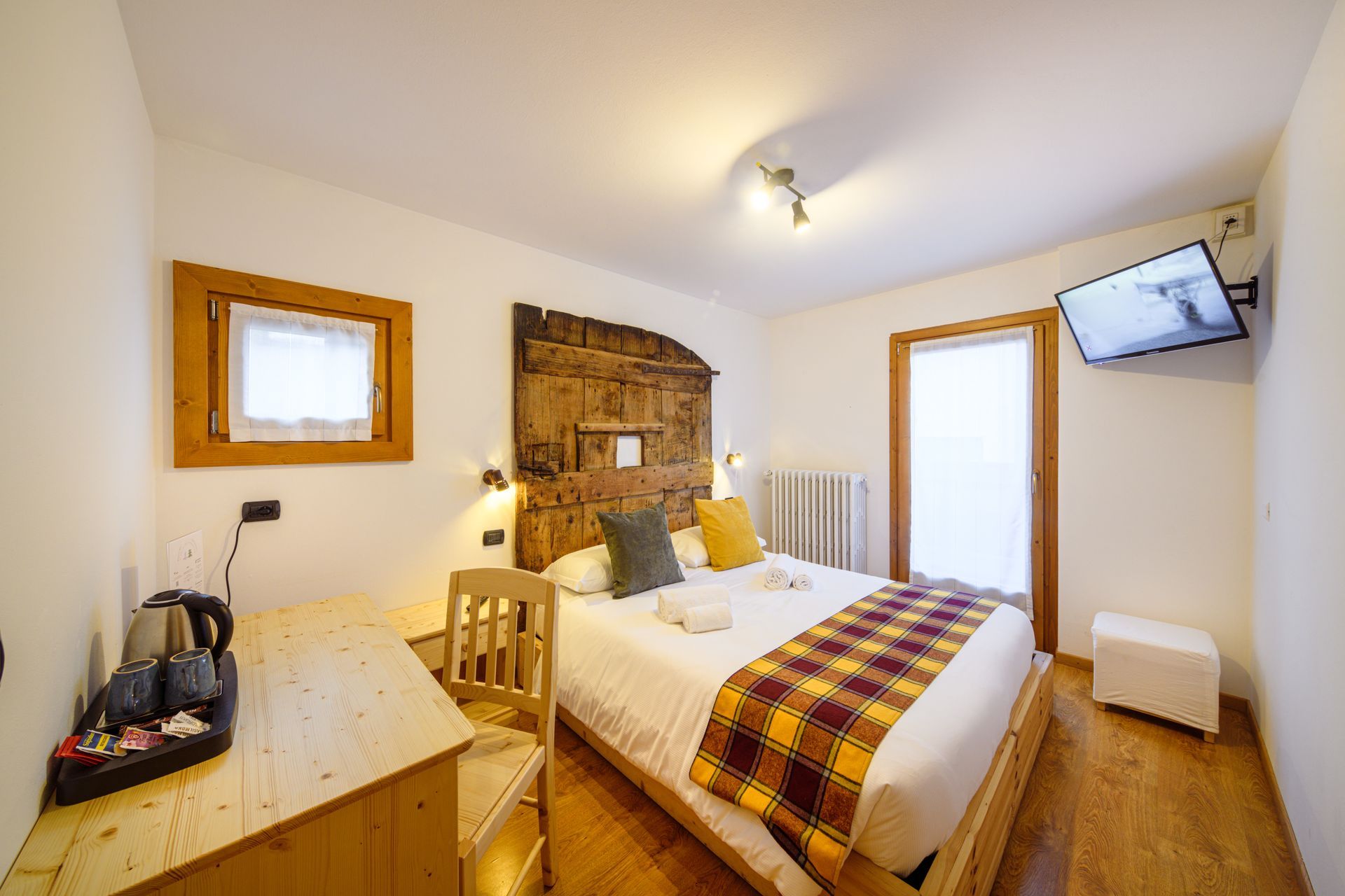 Camera da letto luminosa con letto matrimoniale, mobili in legno