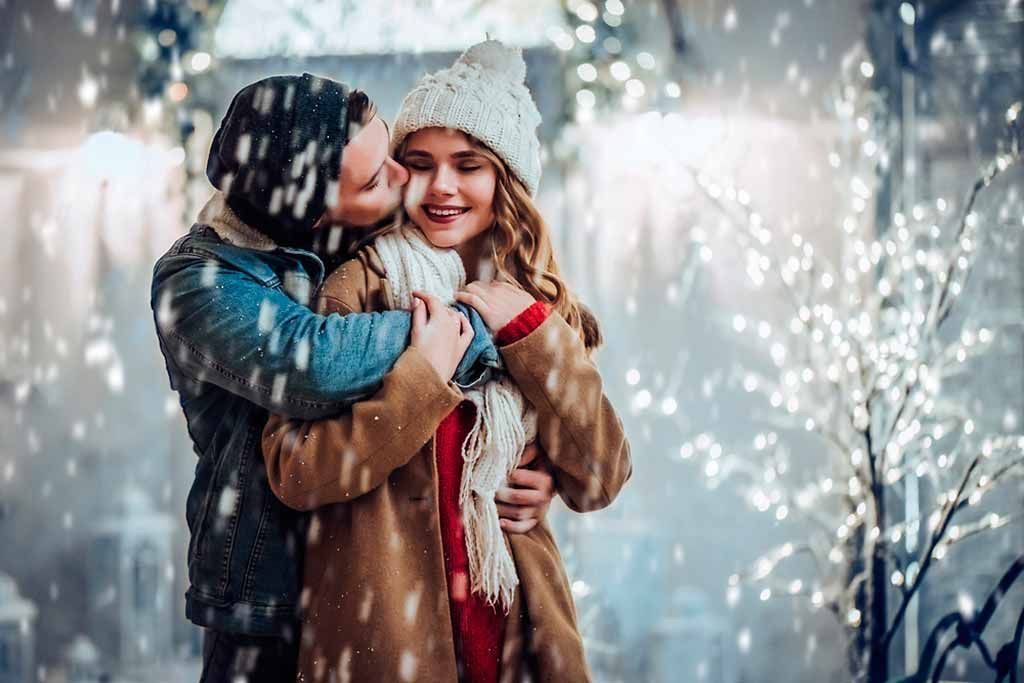 Una coppia si abbraccia sulla neve