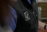 Un gros plan d'une personne portant un gilet noir.