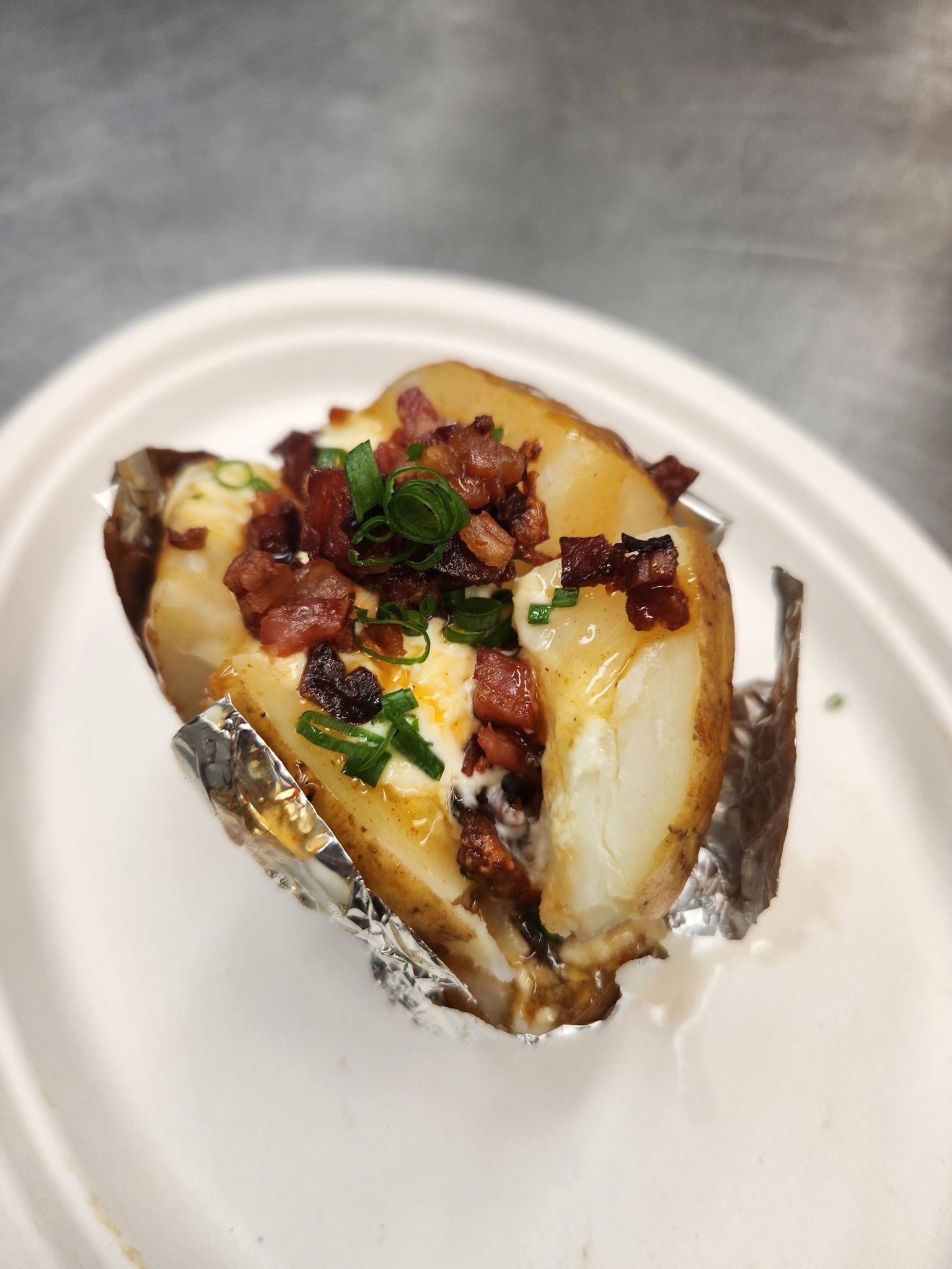 Baked Potato Wrapped in Foil, Topped With Melted Cheese — Tre's Carvery in Mount Sheridan, QLD