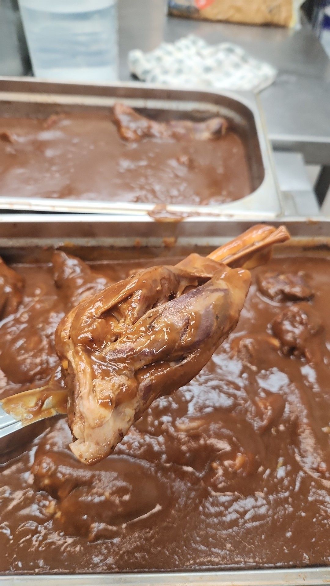 Close-up of a Cooked Meat Shank Held With Metal Tongs — Tre's Carvery in Mount Sheridan, QLD