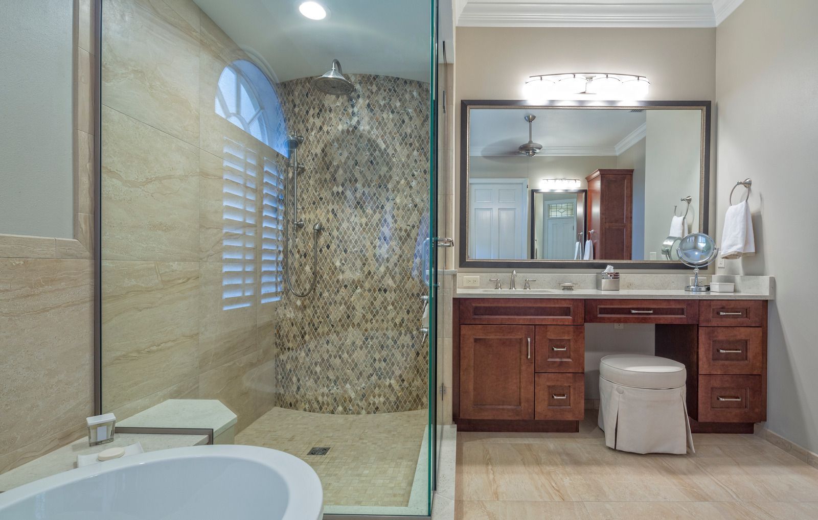 A bathroom with a tub , sink , mirror and walk in shower.