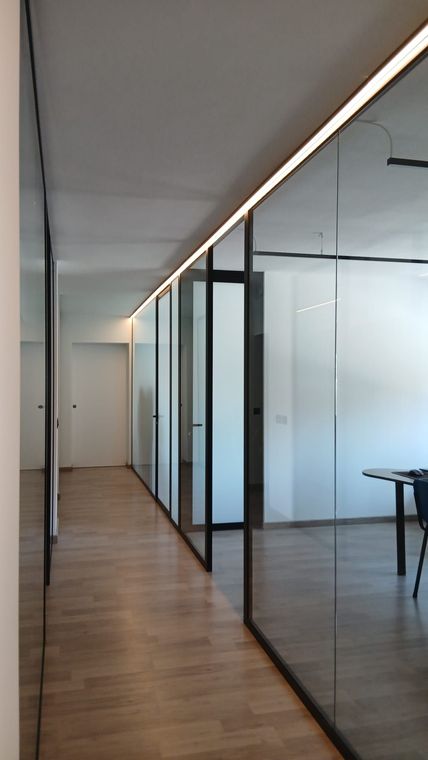 Patio moderno con porte finestre a tutta altezza che si affacciano su una luminosa vista sull'oceano.