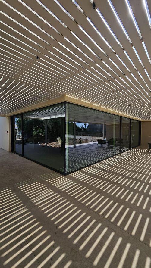 Scala in acciaio parzialmente assemblata in un interno non rifinito, con impalcature e materiali edili.