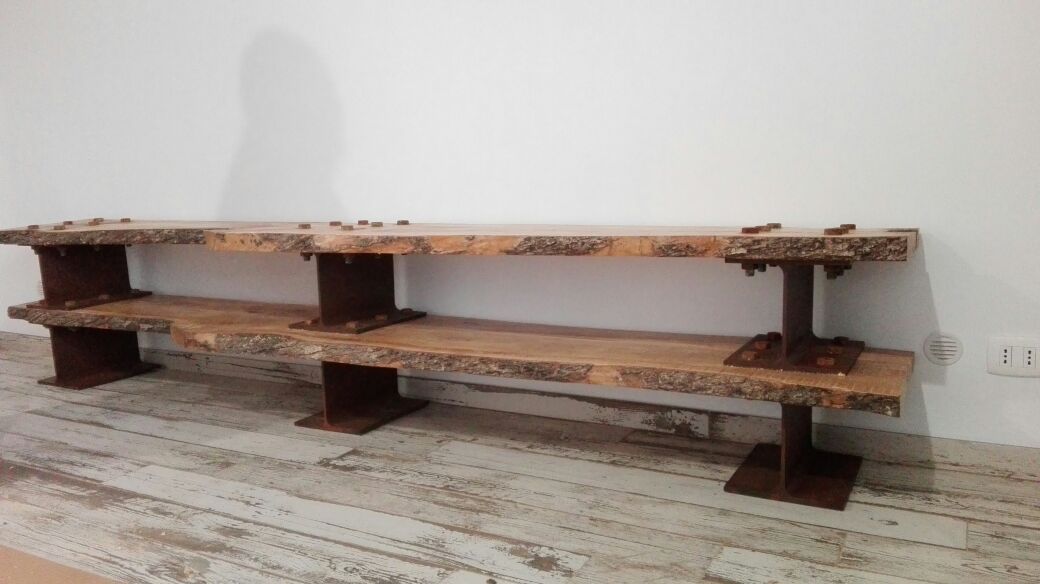 Scaffale lungo e rustico in legno a due ripiani, appoggiato a una parete bianca.