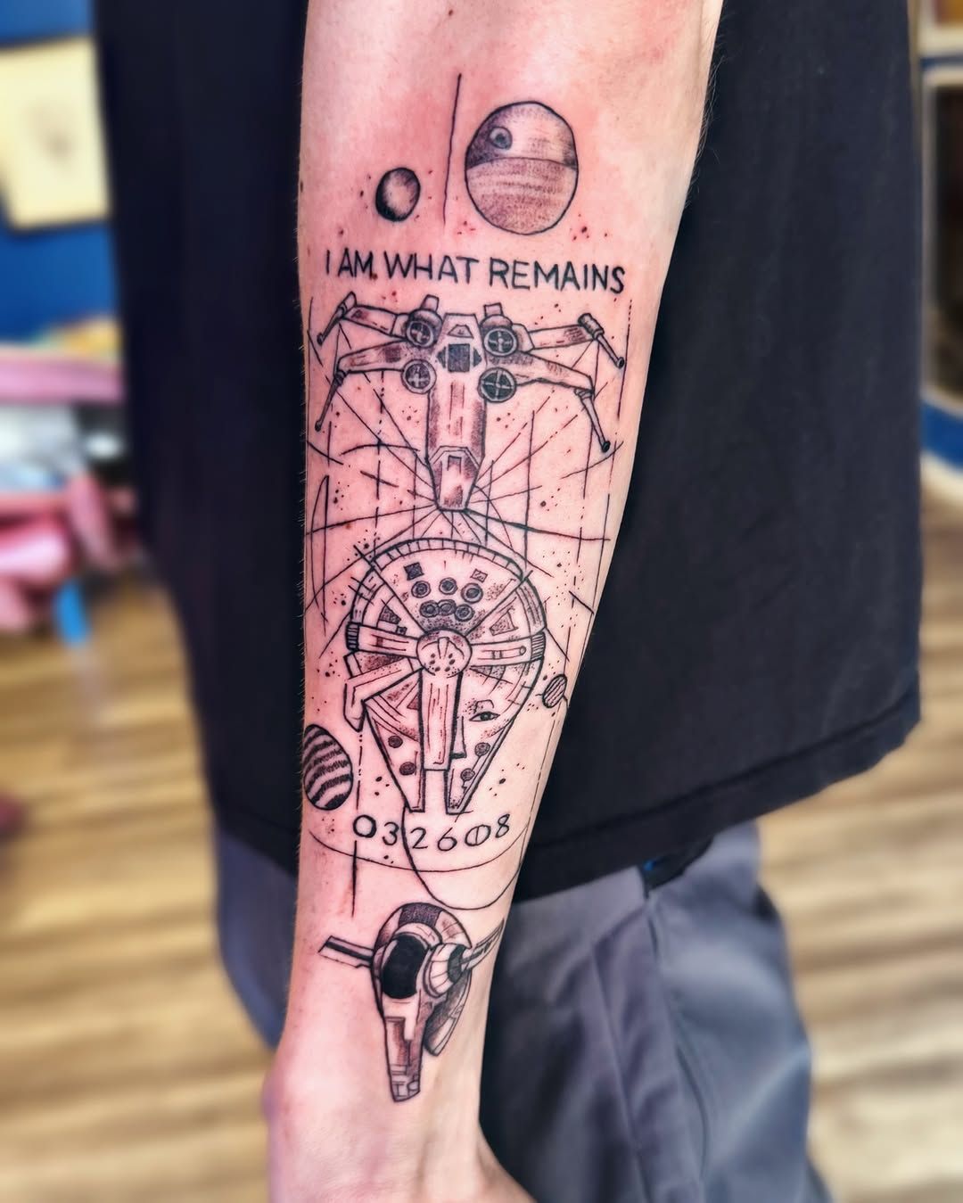 A black-ink tattoo on a forearm featuring Star Wars starships, the Death Star, and the text 