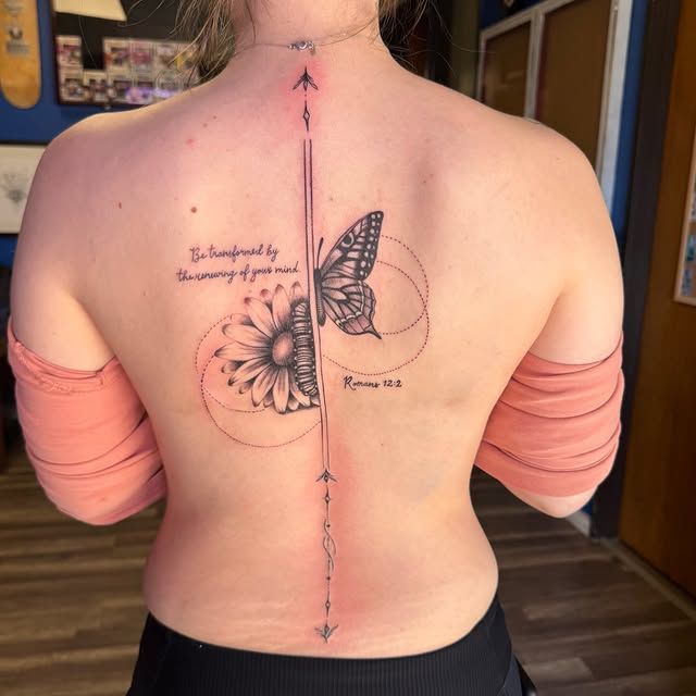 A back tattoo centered along the spine features a vertical line with geometric accents, a sunflower, and a butterfly.