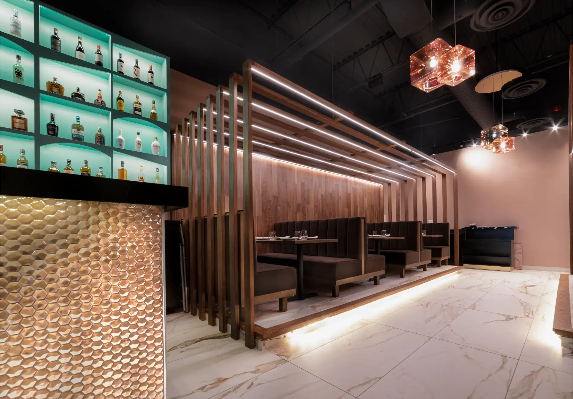 Modern restaurant interior with a bar, booths, and decorative wooden accents. Marble floors and a turquoise liquor display are also featured.