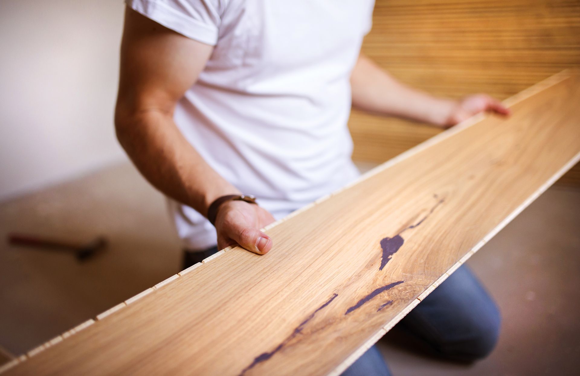A man is holding a piece of wood in his hands.