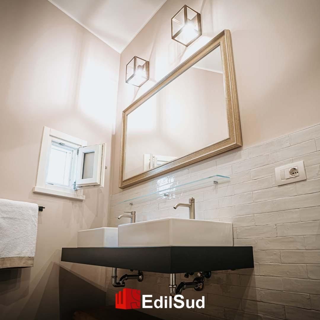 Moderna sala per trattamenti spa con bancone curvo bianco, mensole ad arco, pavimento in legno e poltrona rossa.