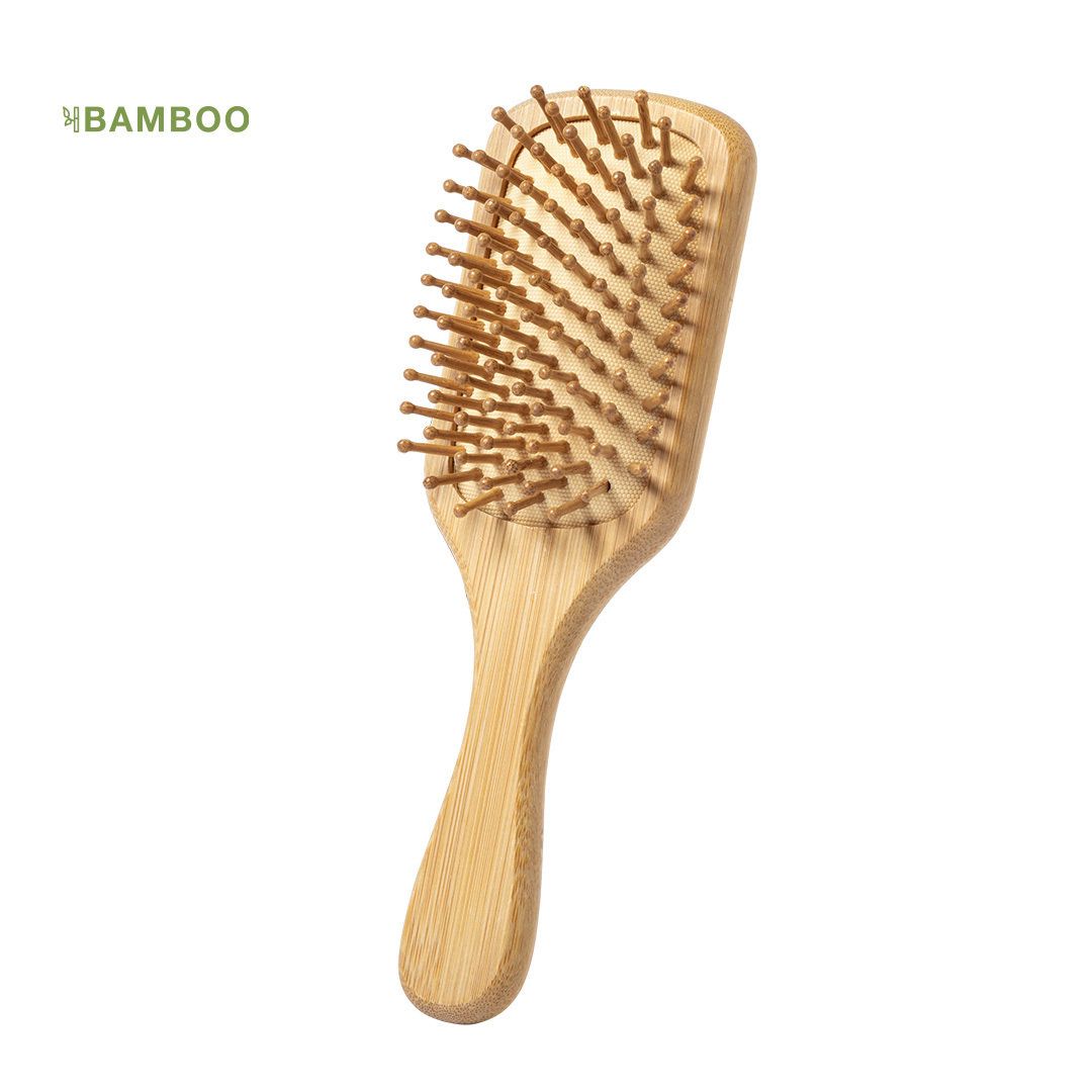 Un cepillo de pelo de madera clara con cerdas de madera, ligeramente inclinado sobre un fondo blanco liso.