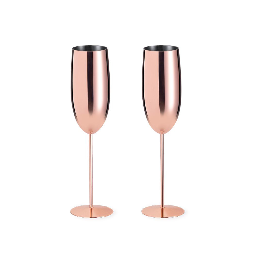 Dos copas de champán de oro rosa con tallos altos y delgados y acabados metálicos pulidos, aisladas sobre un fondo blanco.