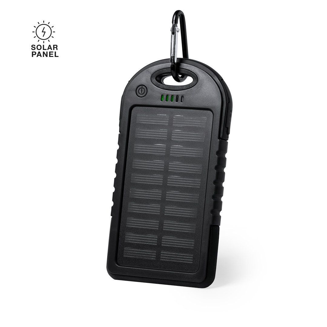 Una batería externa solar portátil, robusta y de color negro, con mosquetón incorporado, panel solar en la superficie e indicadores luminosos de estado.