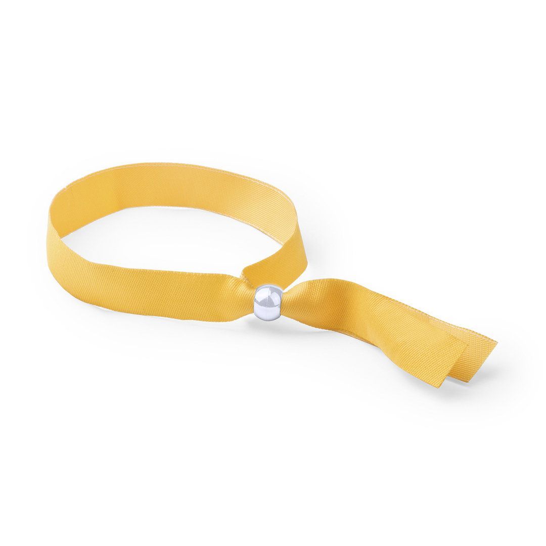 Una pulsera de tela amarilla con un cierre de una sola perla blanca, sobre un fondo blanco liso.