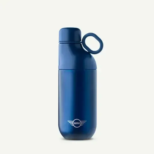 Una botella de agua de color azul oscuro metalizado con la marca MINI y un asa lateral única, sobre un fondo liso de color crema.