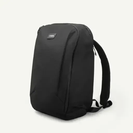 Una mochila minimalista de color negro liso, ladeada sobre un fondo gris claro.
