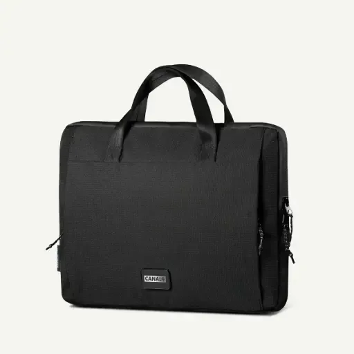 Un maletín rectangular negro para portátil con dos asas superiores y un pequeño logotipo centrado sobre un fondo liso.