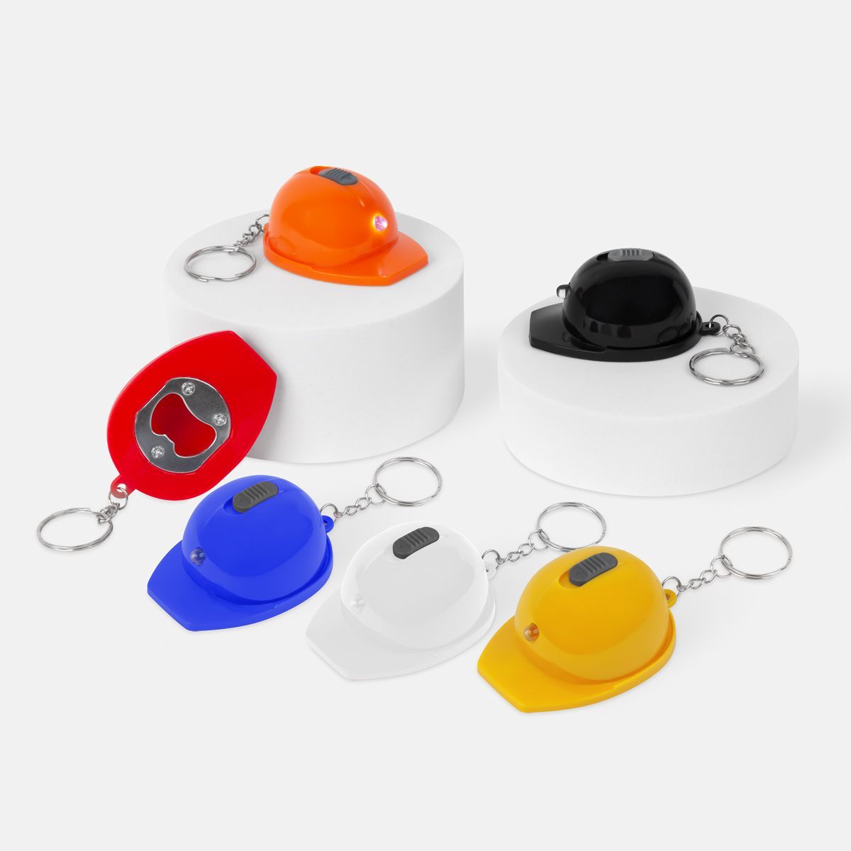 Llaveros con forma de casco de obra con abrebotellas incorporado en color naranja, negro, rojo, azul, blanco y amarillo.