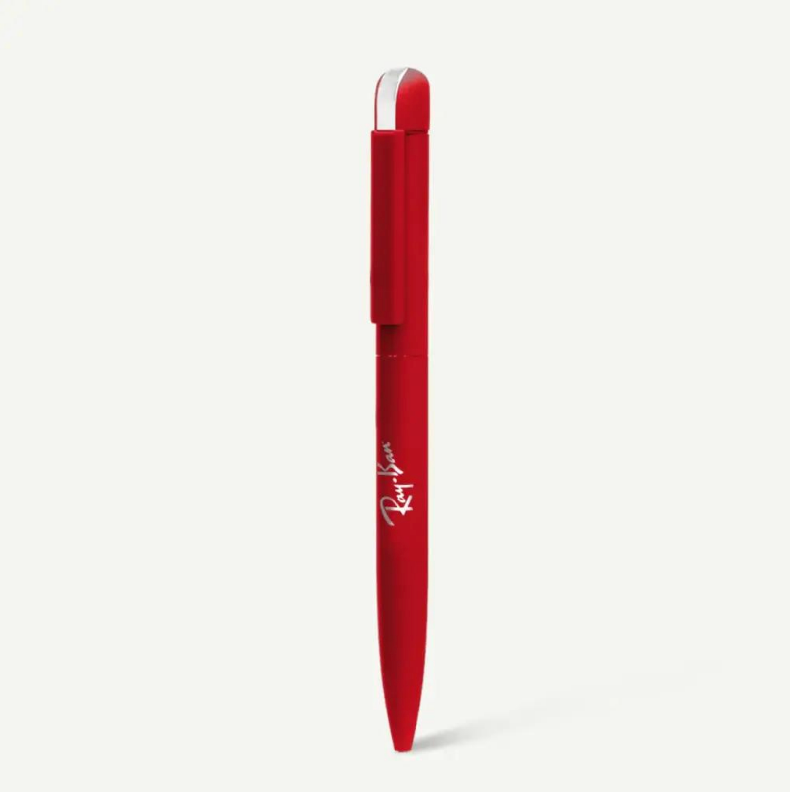 Un bolígrafo retráctil de color rojo con un detalle plateado en la parte superior y el logotipo blanco de Ray-Ban impreso en el cuerpo.