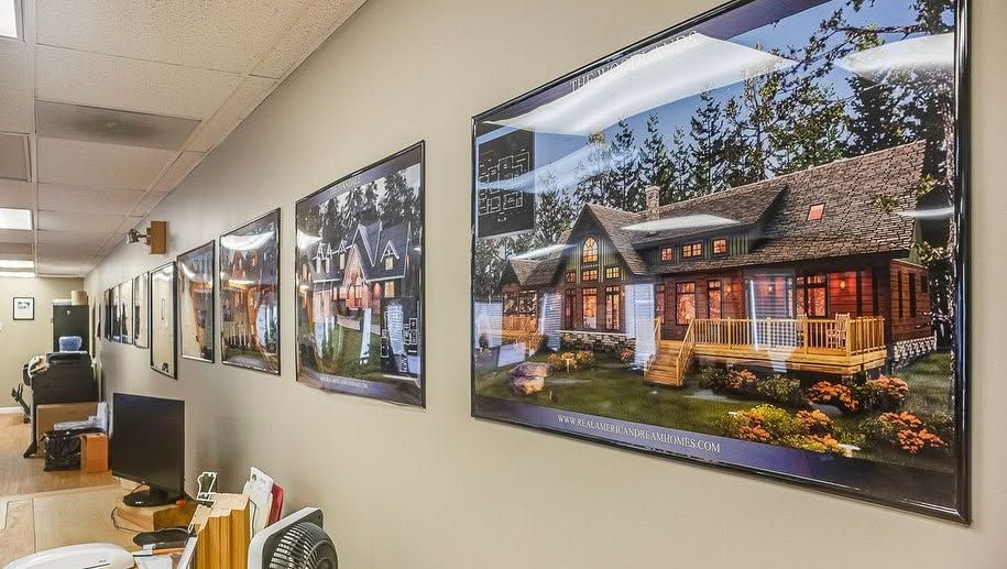 Office hallway with framed landscape photos on beige walls and ceiling lights overhead