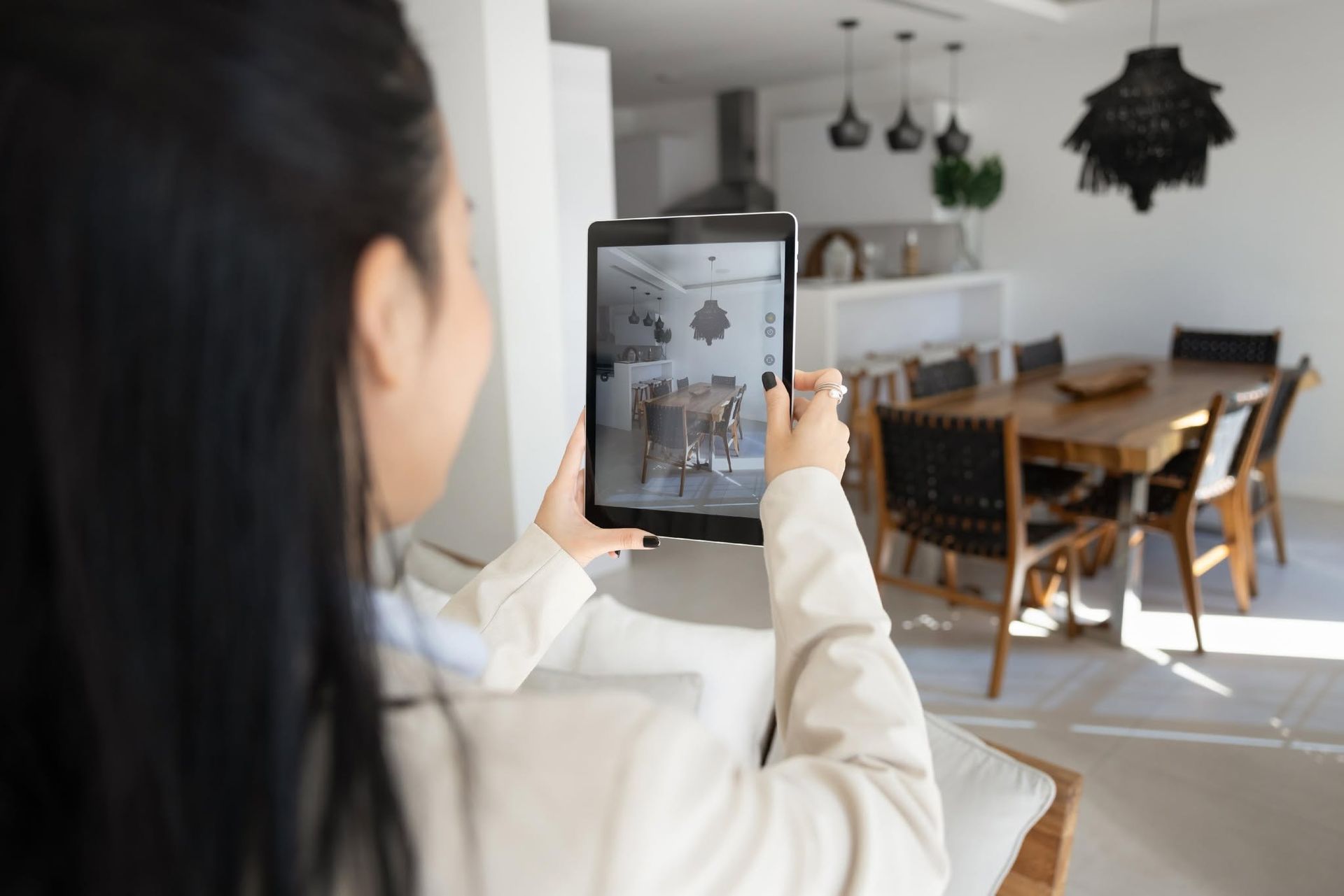 Person photographing a bright dining room with a tablet