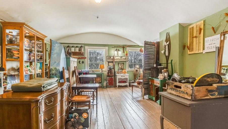Vintage shop interior with wooden floors, glass display cabinets, and antique decor under soft natural light