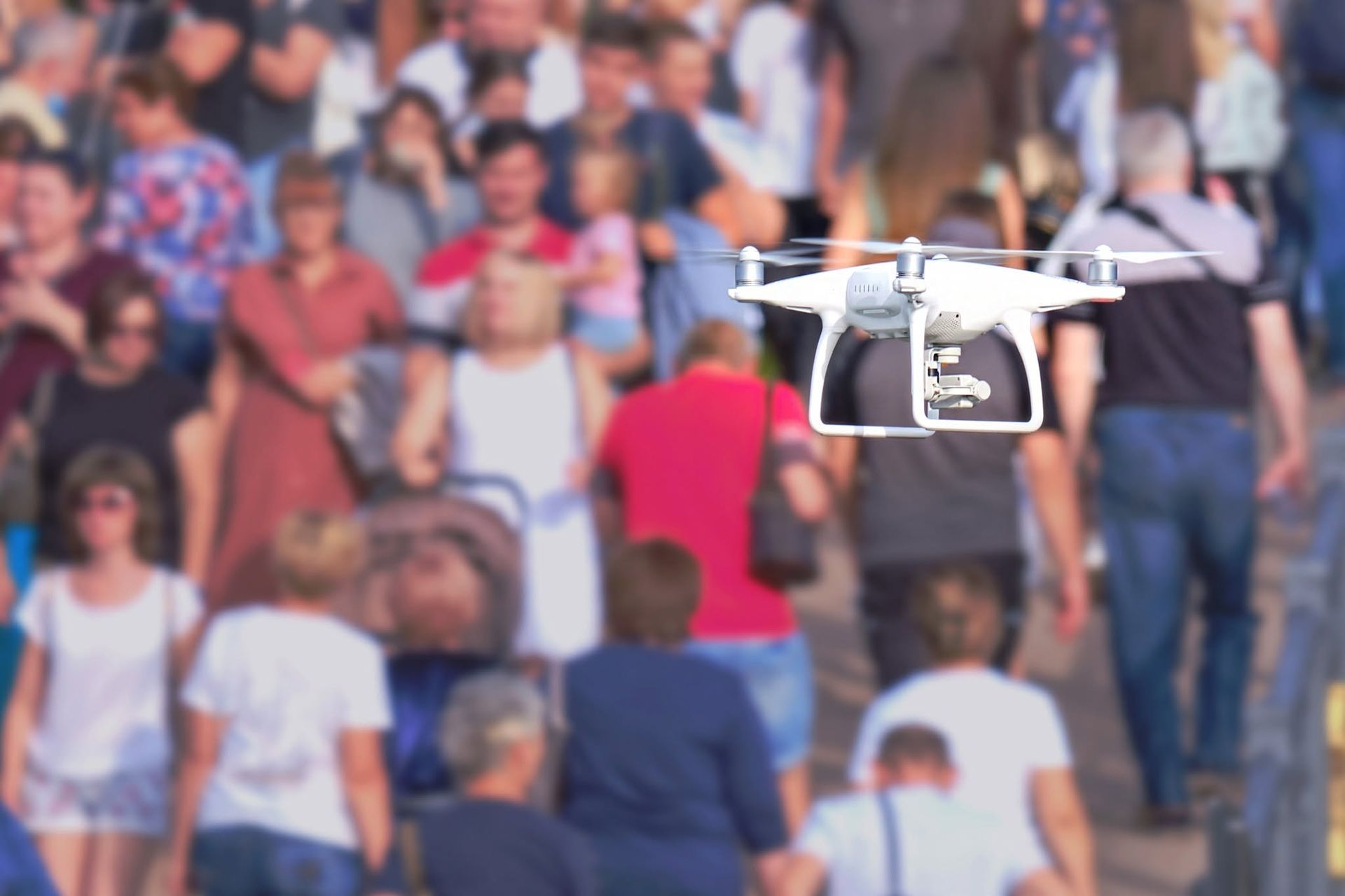Drone hovering over a blurred crowd outdoors