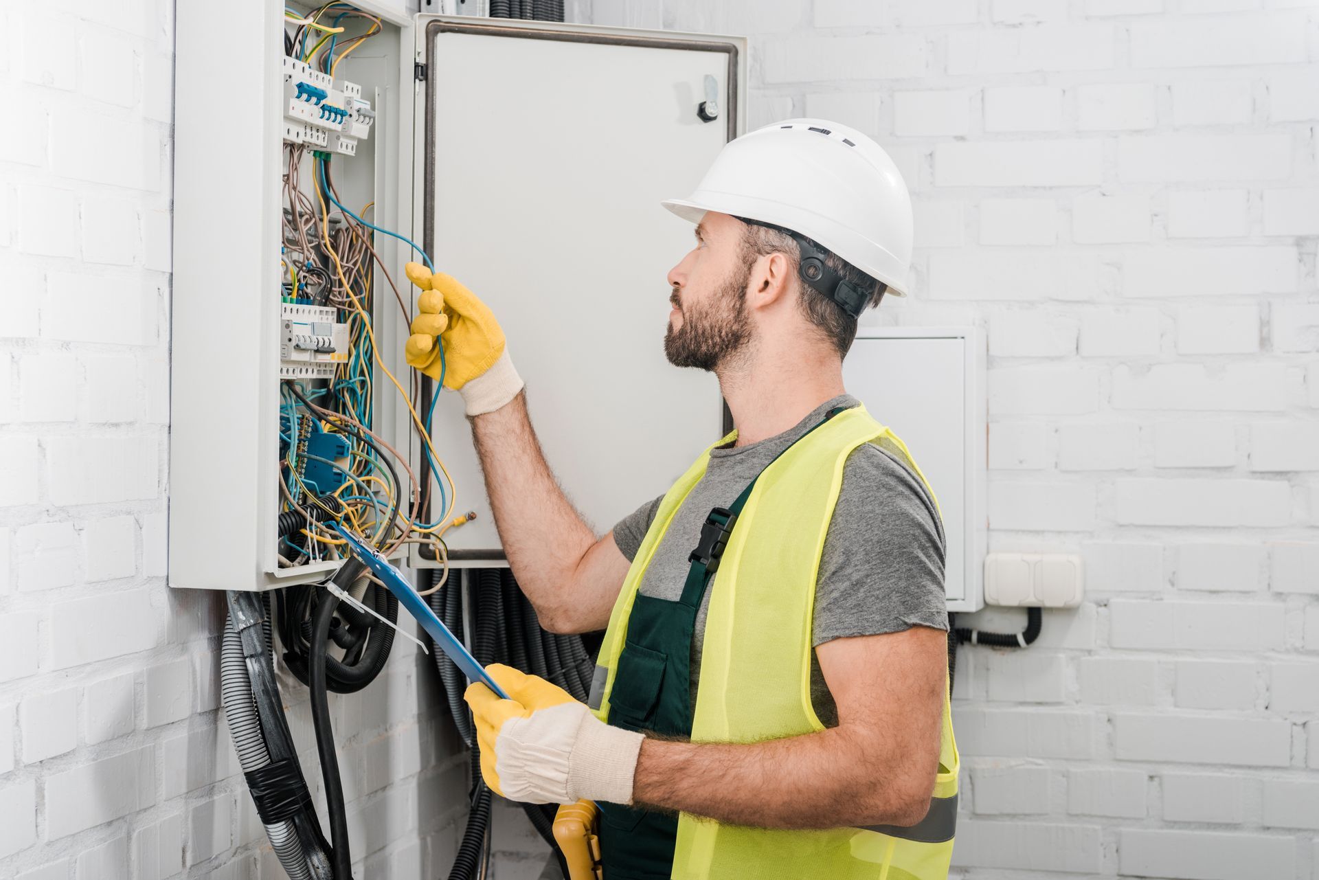 Electrical Contractor inspecting and wiring an electrical panel during a commercial installation. Electrical Contractor inspecting and wiring an electrical panel during a commercial installation.