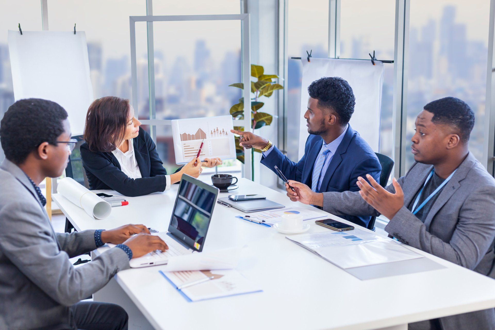 A group of business people are sitting around a table having a meeting.