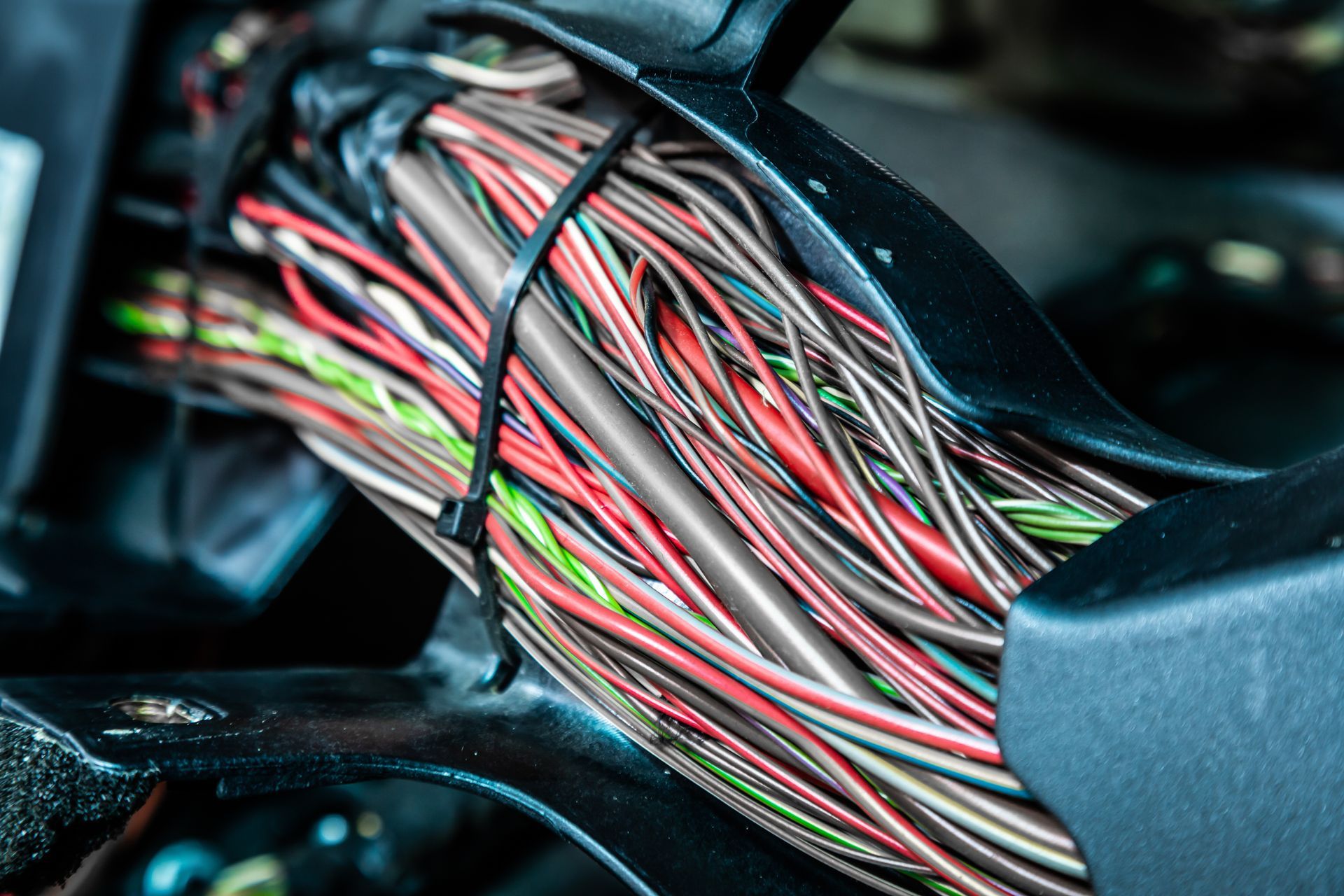 Bundle of multicolored wires routed through a vehicle interior panel opening