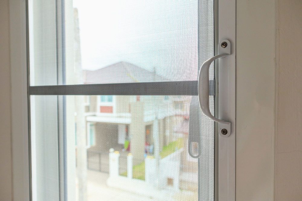 A Close Up of a Sliding Screen Door With a Handle — Budget Screens & Awnings in Kyogle, NSW