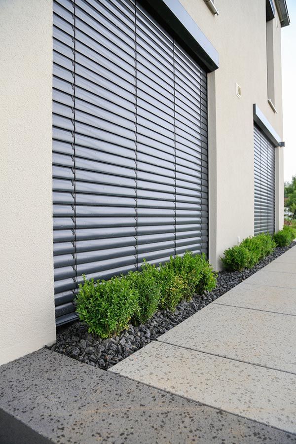 A Building With a Row of Plants in Front of It — Budget Screens & Awnings in Casino, NSW