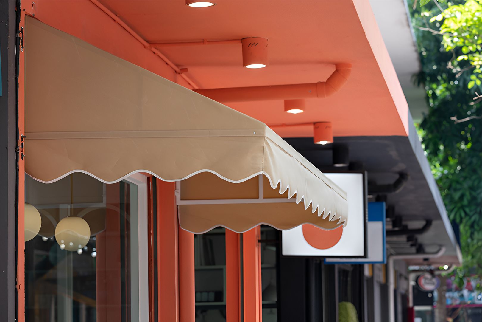 Beige fabric awnings over storefront windows — Budget Screens & Awnings in South Lismore, NSW