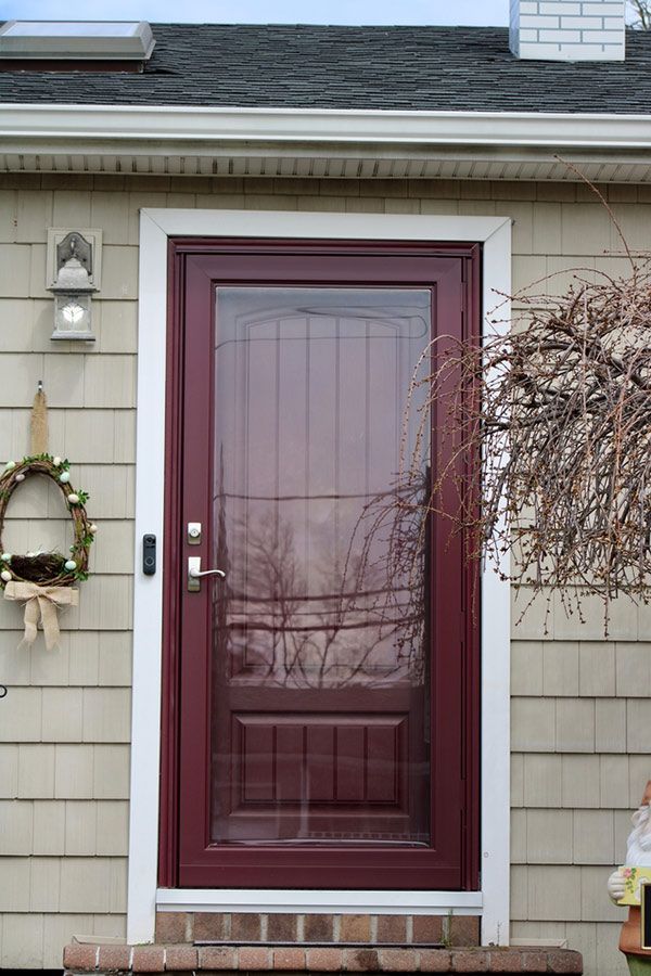 A Red Door With a Glass Window is on the Side of a House — Budget Screens & Awnings in Lismore, NSW