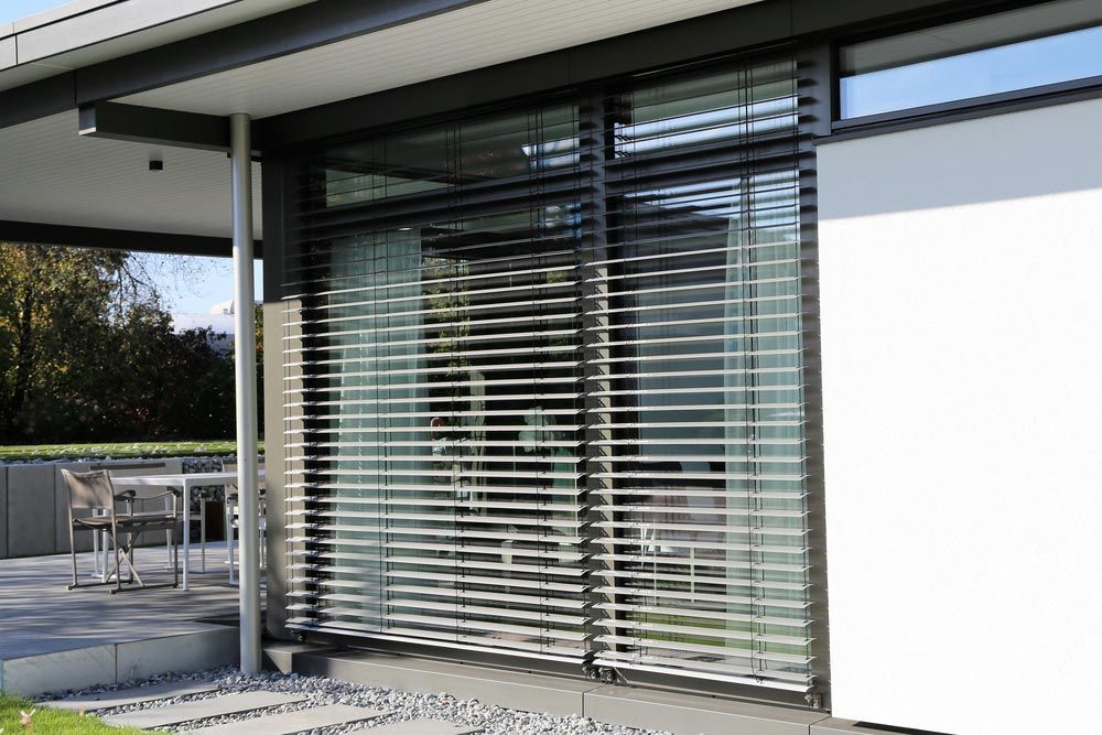 A House With a Large Window With Blinds on It — Budget Screens & Awnings in Evans Head, NSW