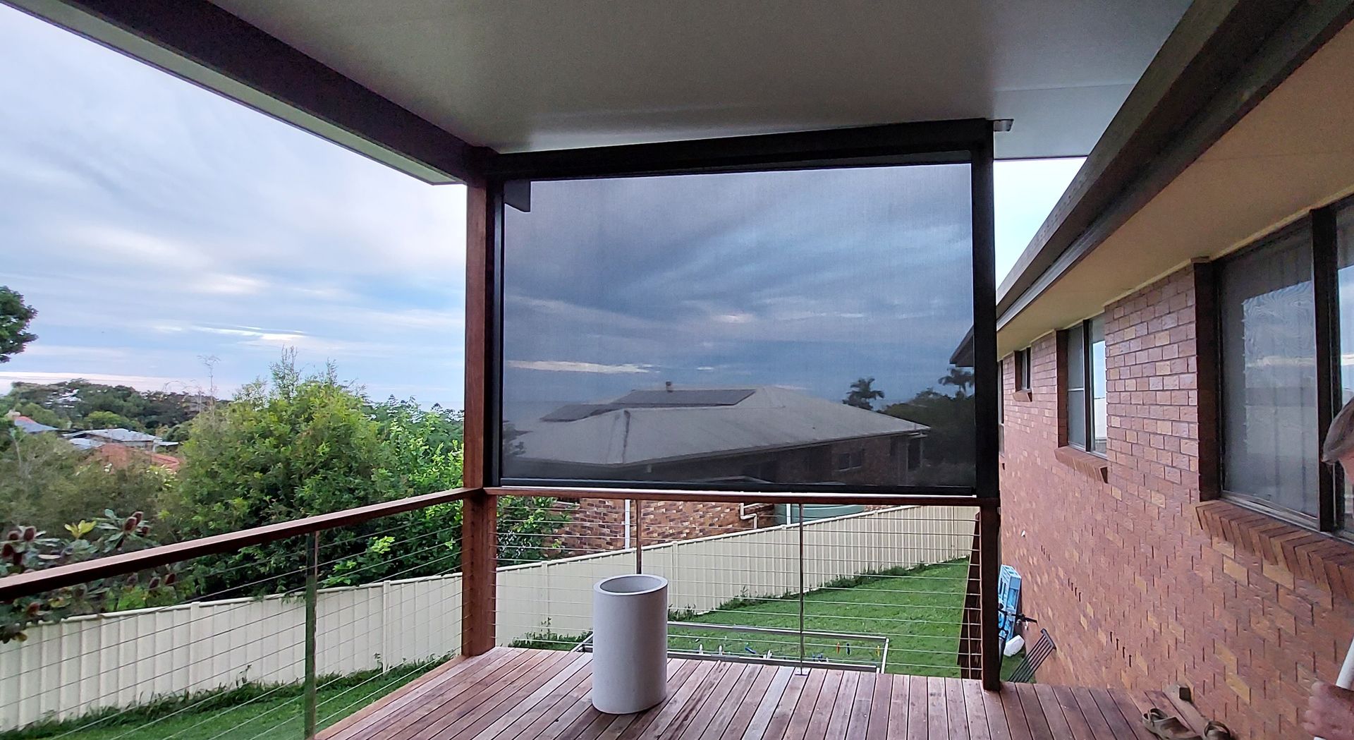 A black mesh outdoor privacy screen installed on a wooden deck — Budget Screens & Awnings in South Lismore, NSW