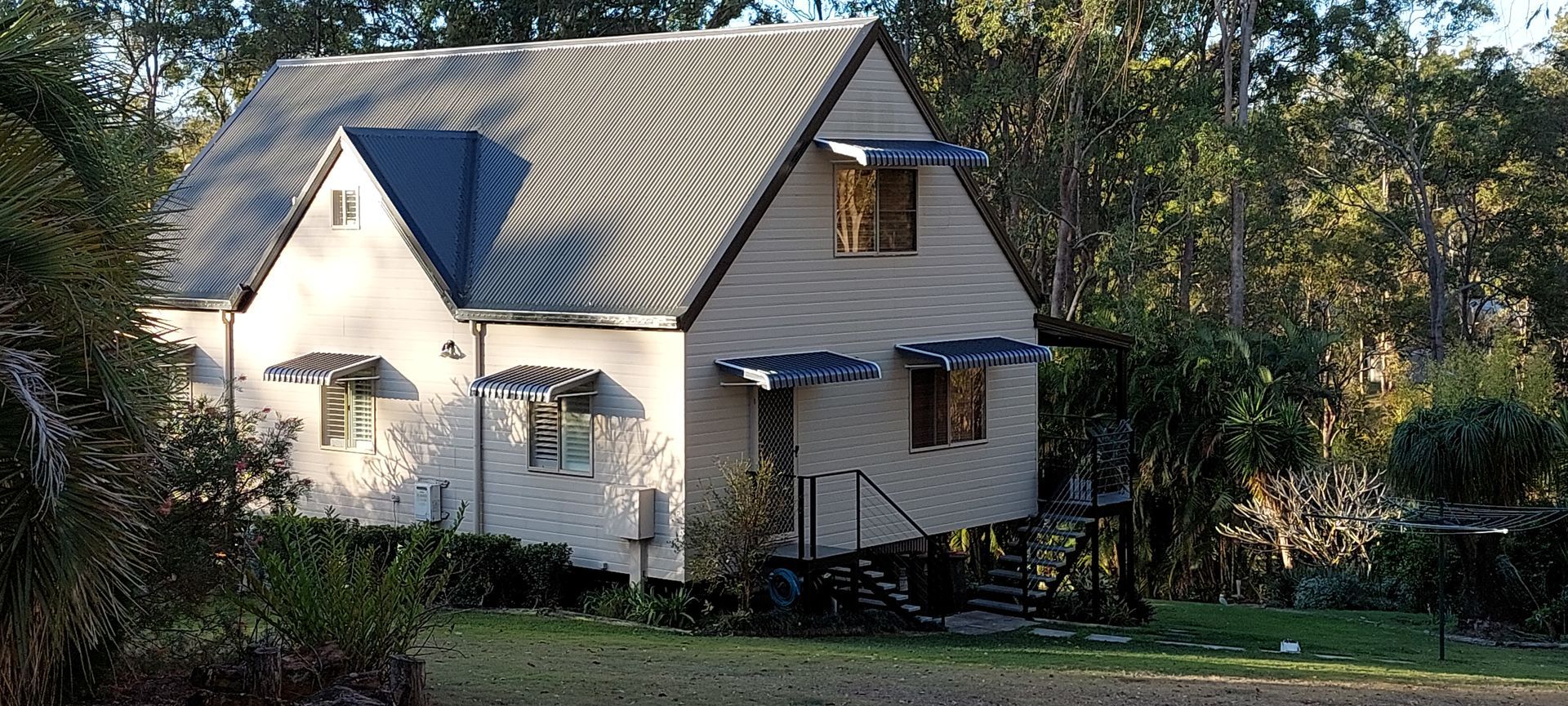 A two-story, light-colored house with a dark metal roof — Budget Screens & Awnings in South Lismore, NSW