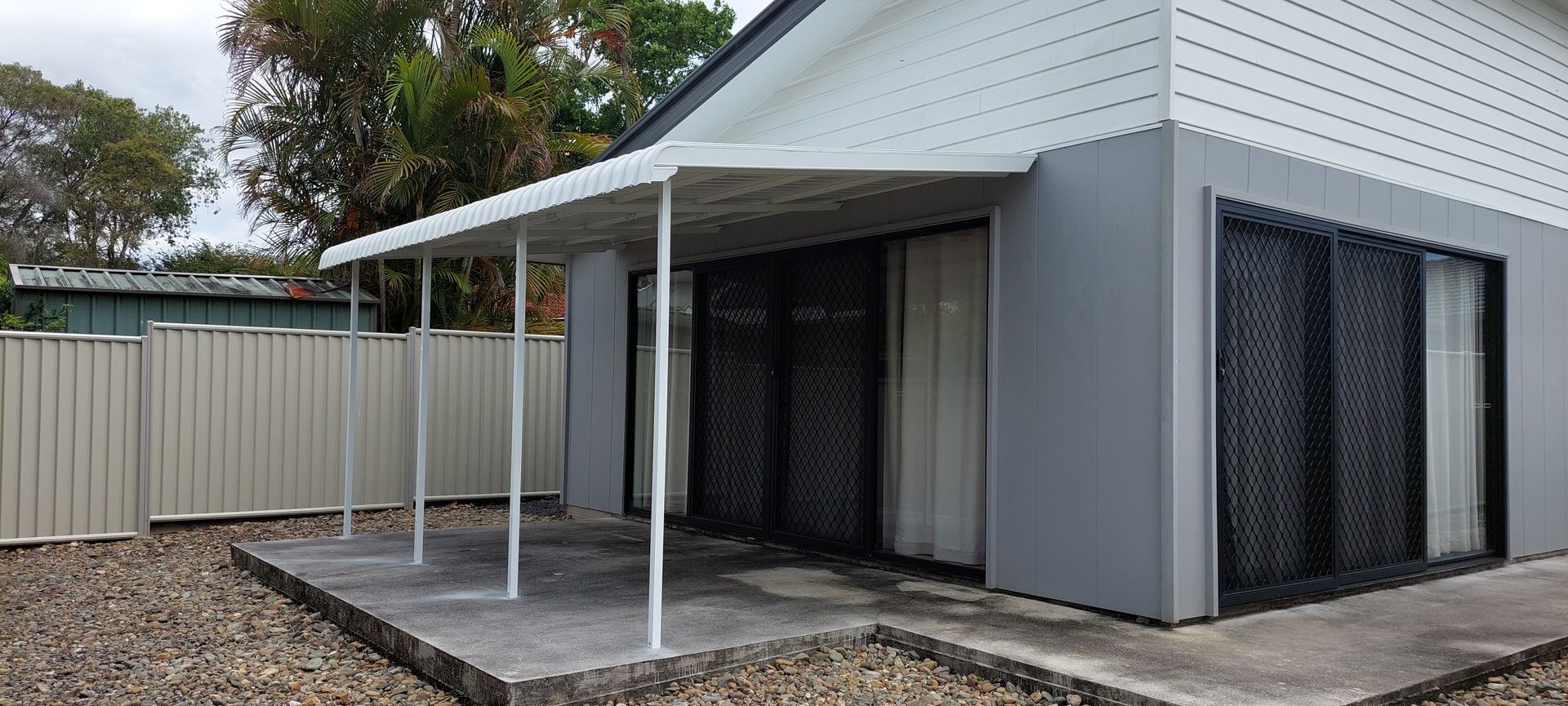 A gray and white house with a patio covered by a white metal awning — Budget Screens & Awnings in South Lismore, NSW
