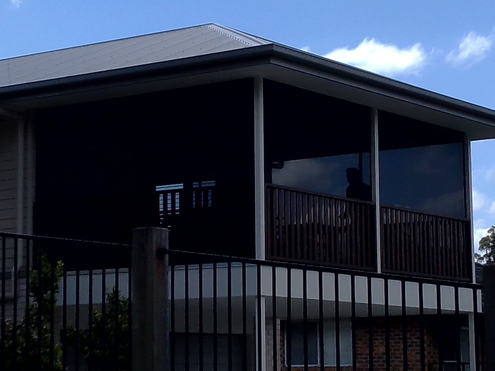 A two-story house with a screened-in upper balcony — Budget Screens & Awnings in South Lismore, NSW