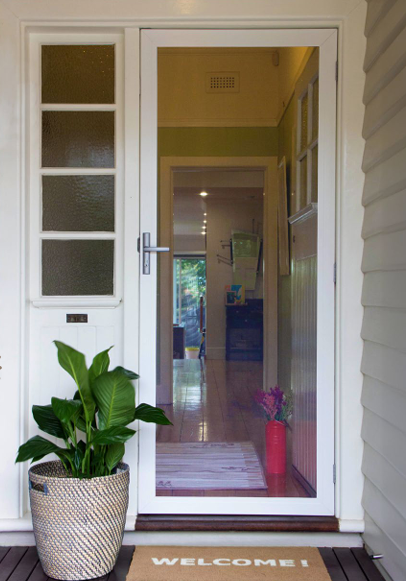 A Fenced in Door With a Plant in Front of It — Budget Screens & Awnings in South Lismore, NSW