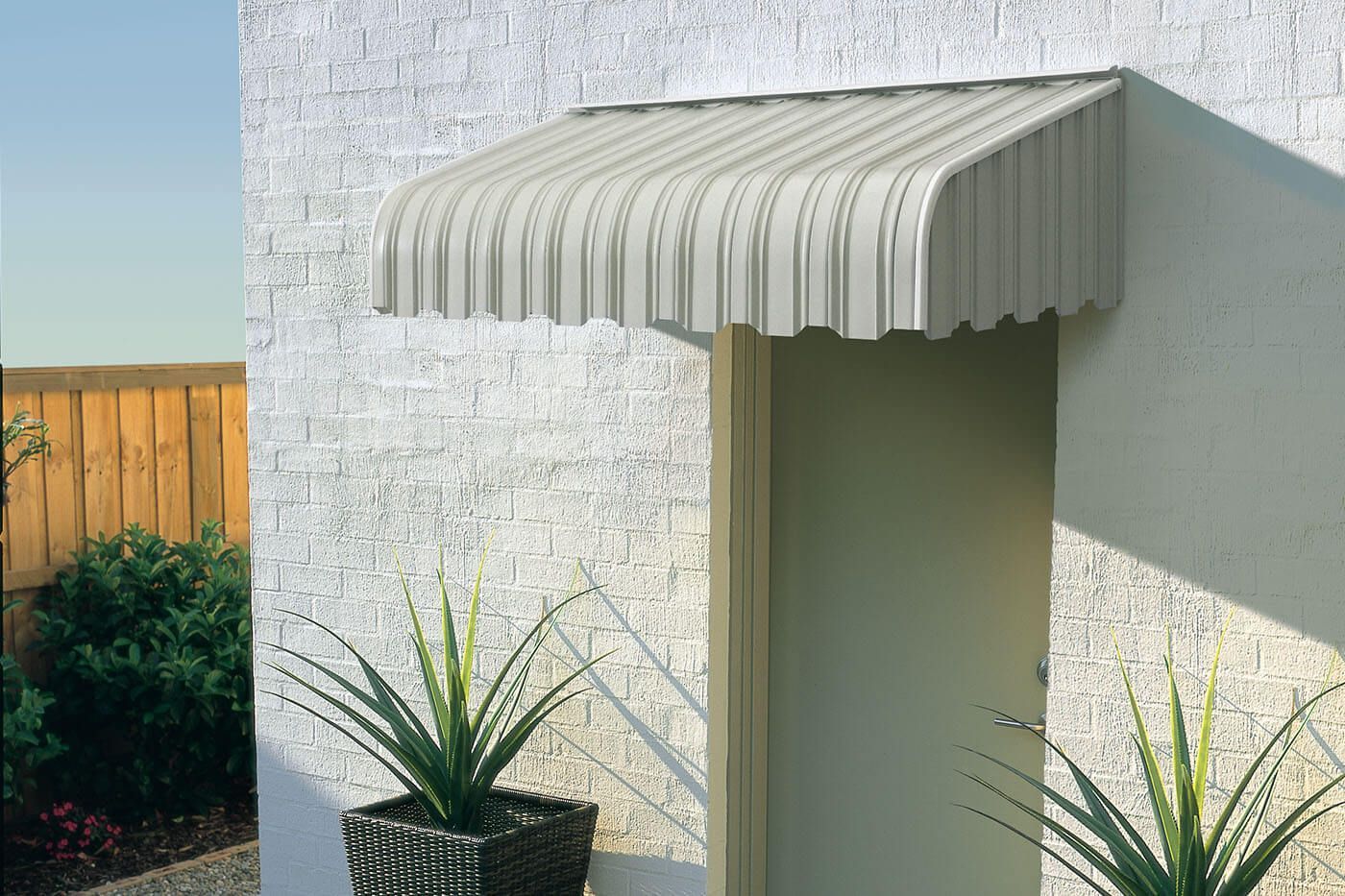 Striped Metal Awning Outside a single door— Budget Screens & Awnings in South Lismore, NSW