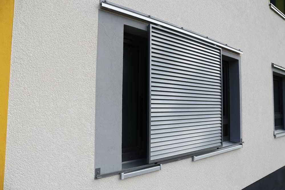 A Building With Sliding Shutters on the Windows — Budget Screens & Awnings in South Lismore, NSW