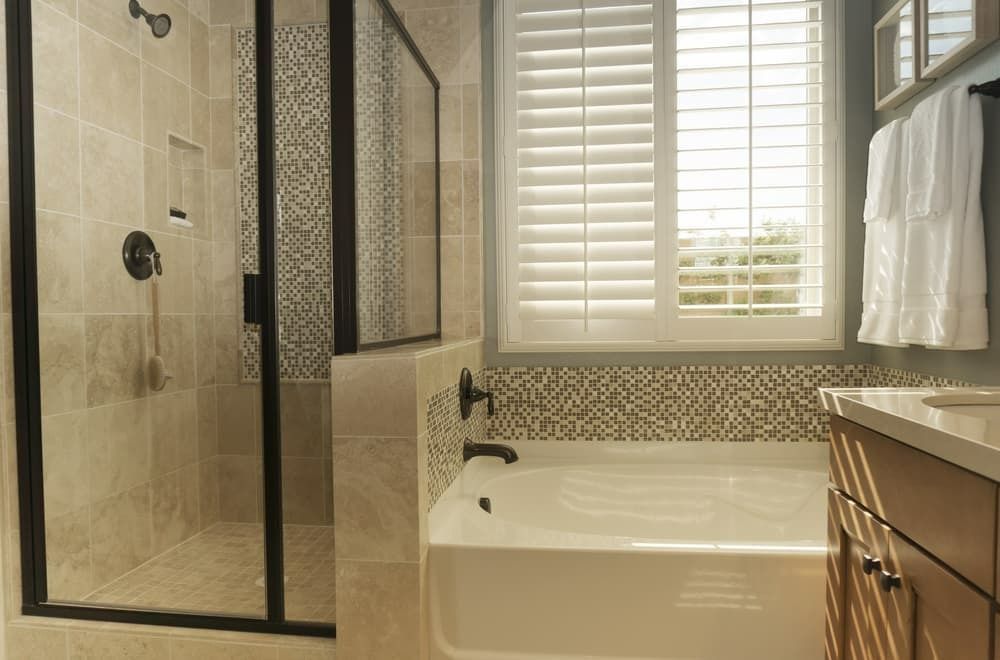 A Bathroom With a Tub, Sink, Shower and Window — Budget Screens & Awnings in South Lismore, NSW