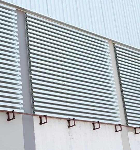 A Building With a Lot of Windows and Shutters on It — Budget Screens & Awnings in South Lismore, NSW