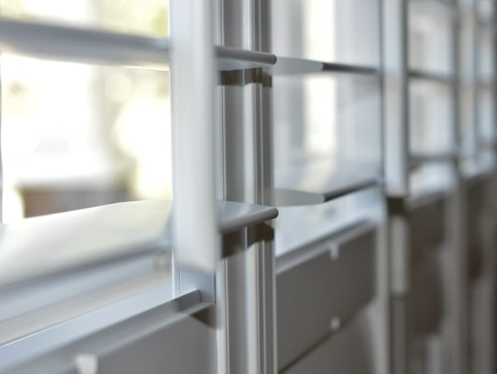 A Close Up of a Metal Railing With a Window in the Background — Budget Screens & Awnings in South Lismore, NSW