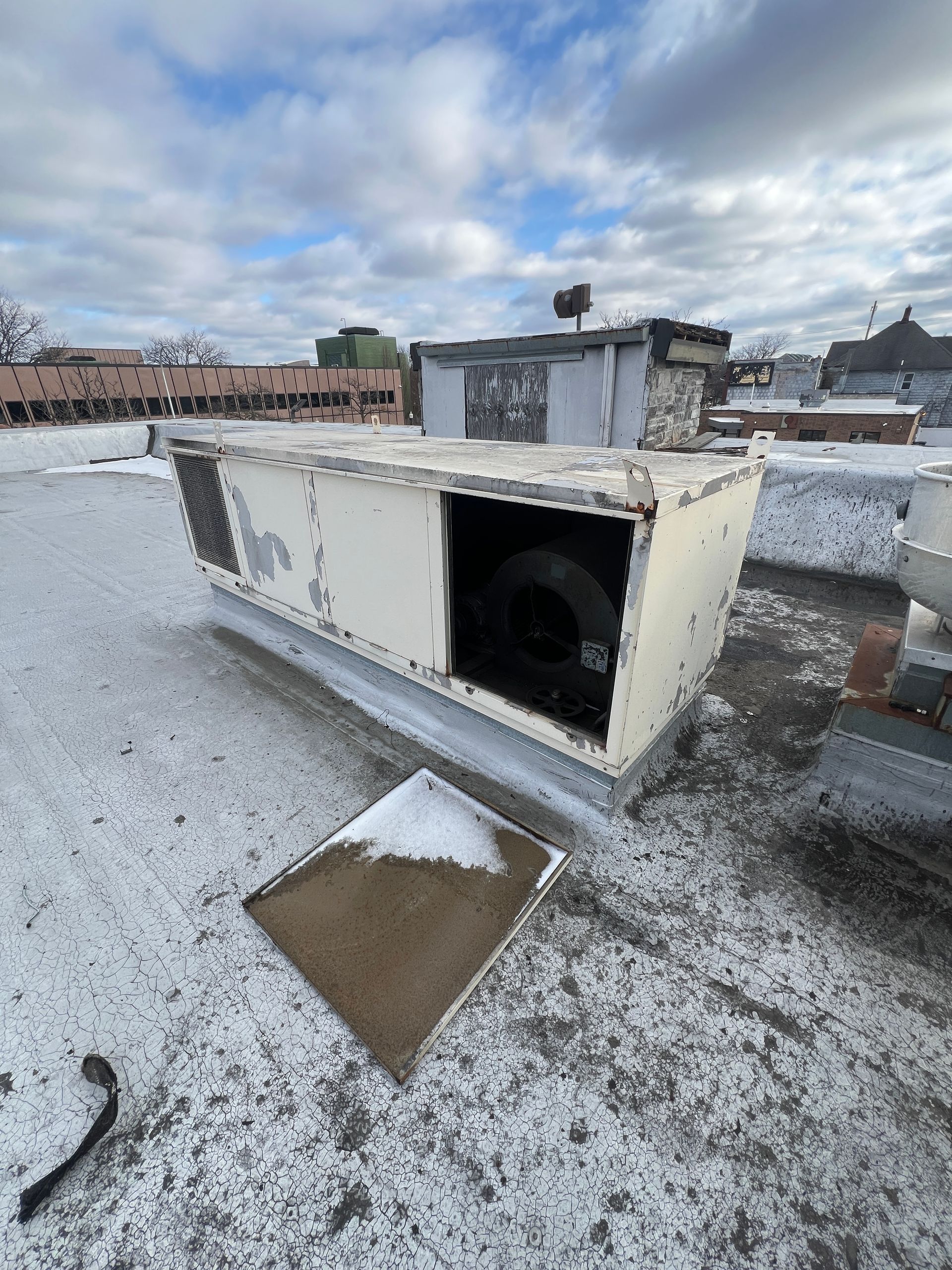 Royal Oak Rooftop HVAC unit with an open side panel, showing a large black fan against a cloudy sky.