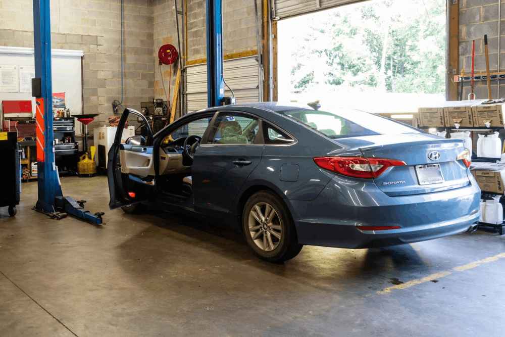 Auto repair near Southwest Charlotte, NC, at Compton’s Automotive. Image of a blue Hyundai Sonata inside the service shop with the driver door open, ready for inspection and maintenance.