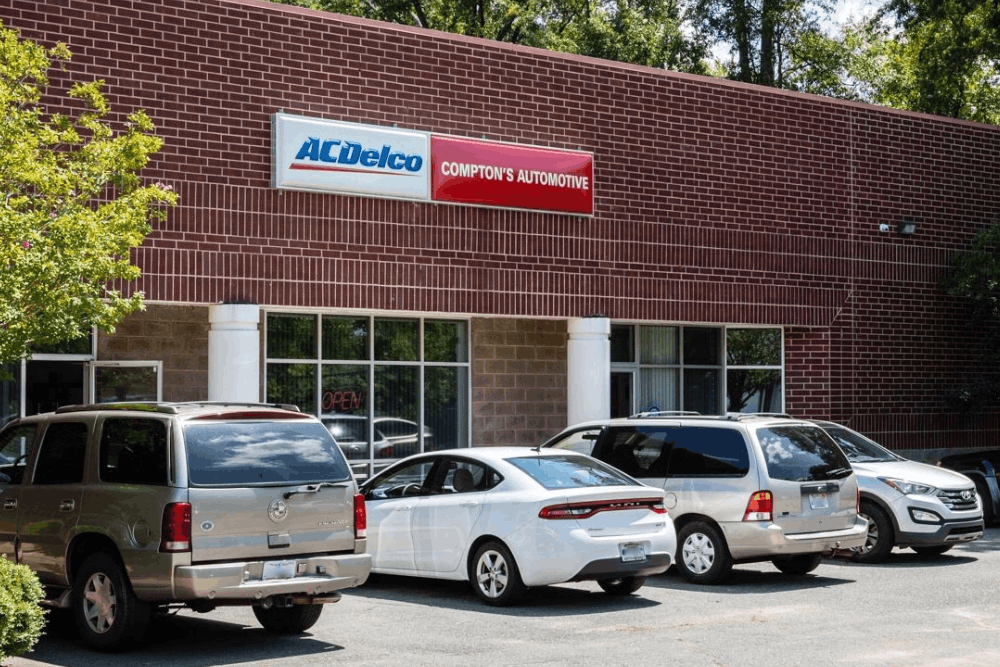 Image of the storefront with Compton’s Automotive signage and customer vehicles outside.