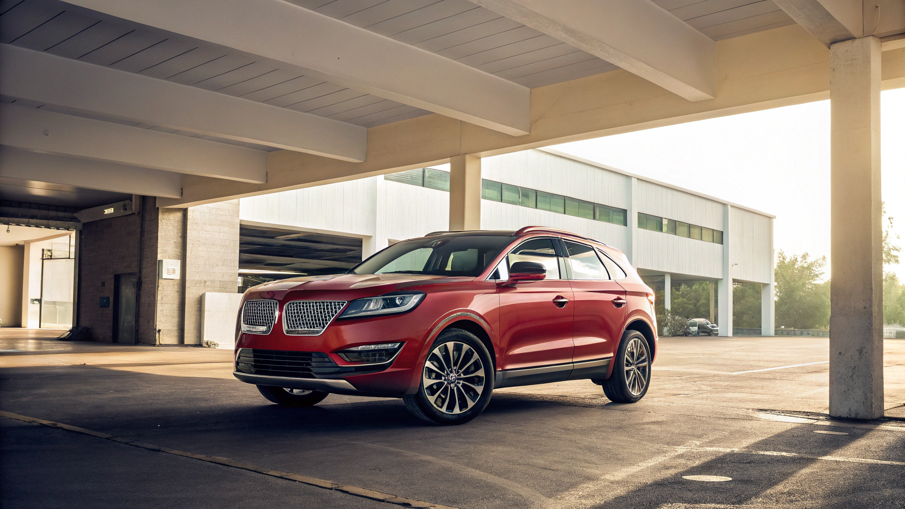 A sleek red SUV is parked in a sunlit, modern parking garage, conveying a sense of elegance and adventure.