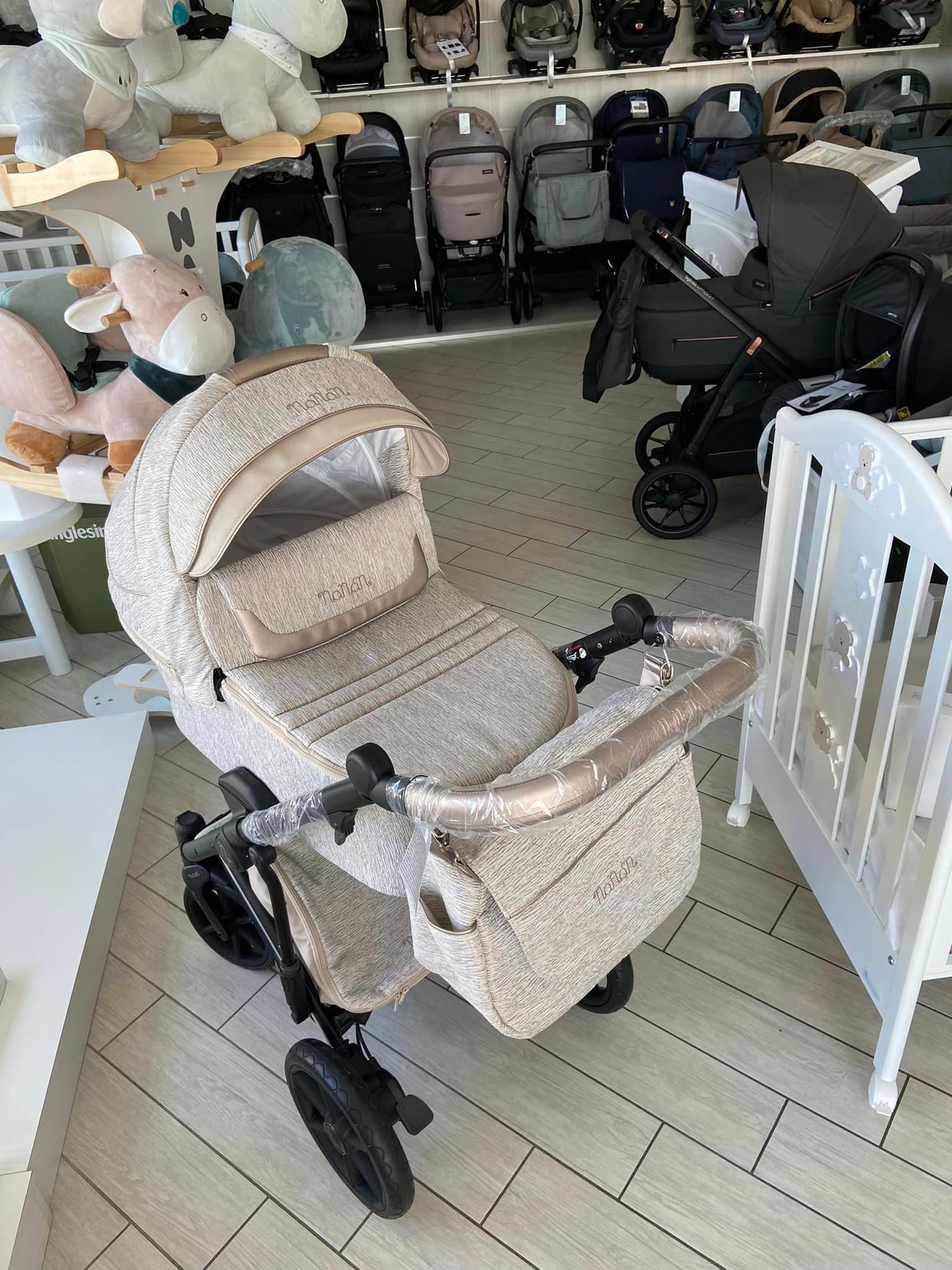 Esposizione di passeggini con modelli beige, neri e bianchi in una corsia di un negozio.